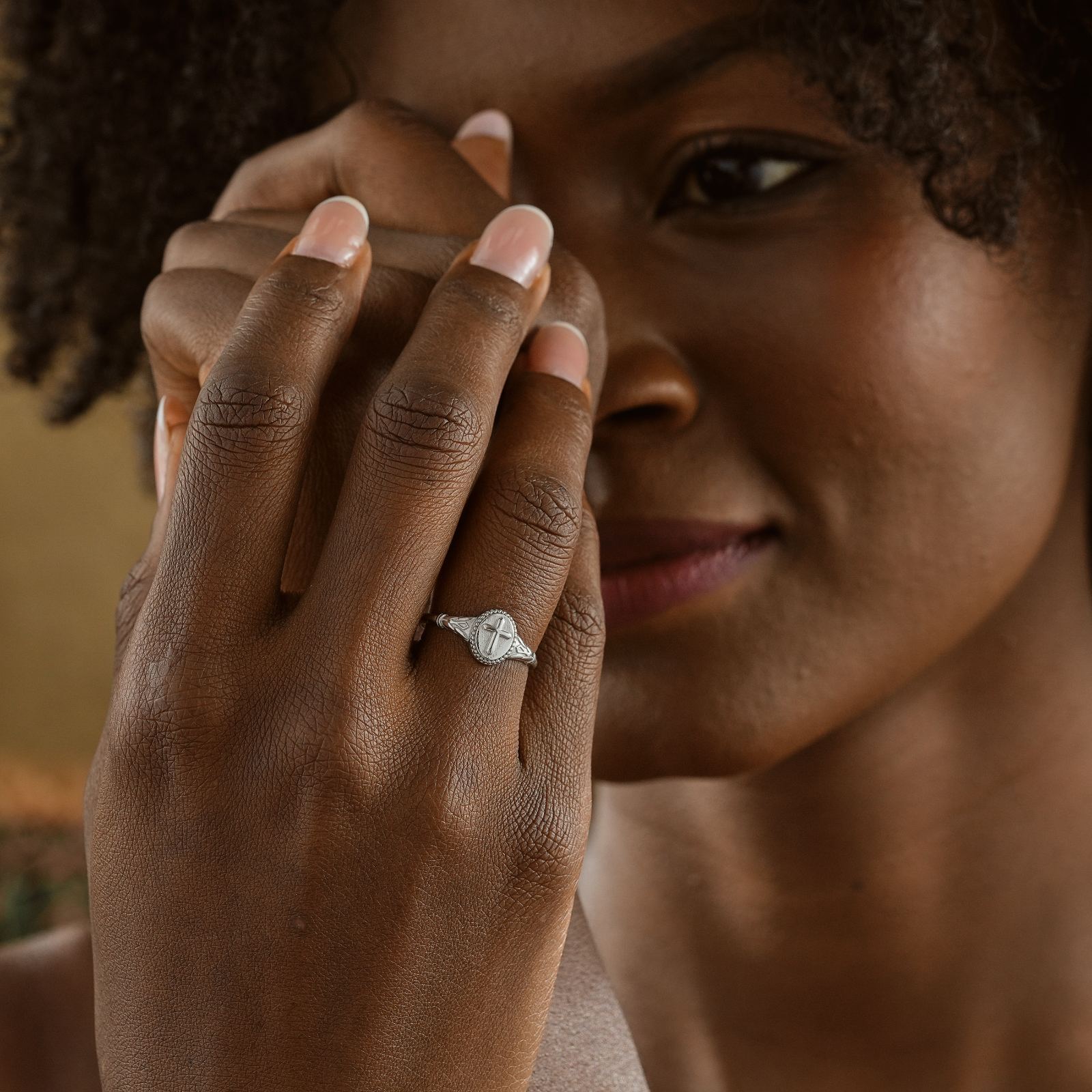 Woman showing a Vintage Cross Signet Ring, elegantly designed with intricate details on her hand.