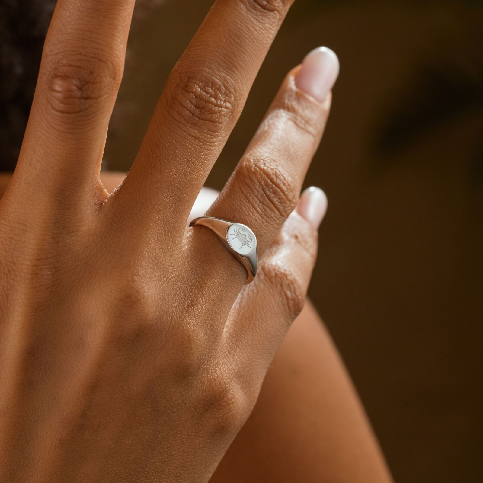 Personalized Zodiac Signet Ring on a hand showing intricate design, perfect for astrology lovers.